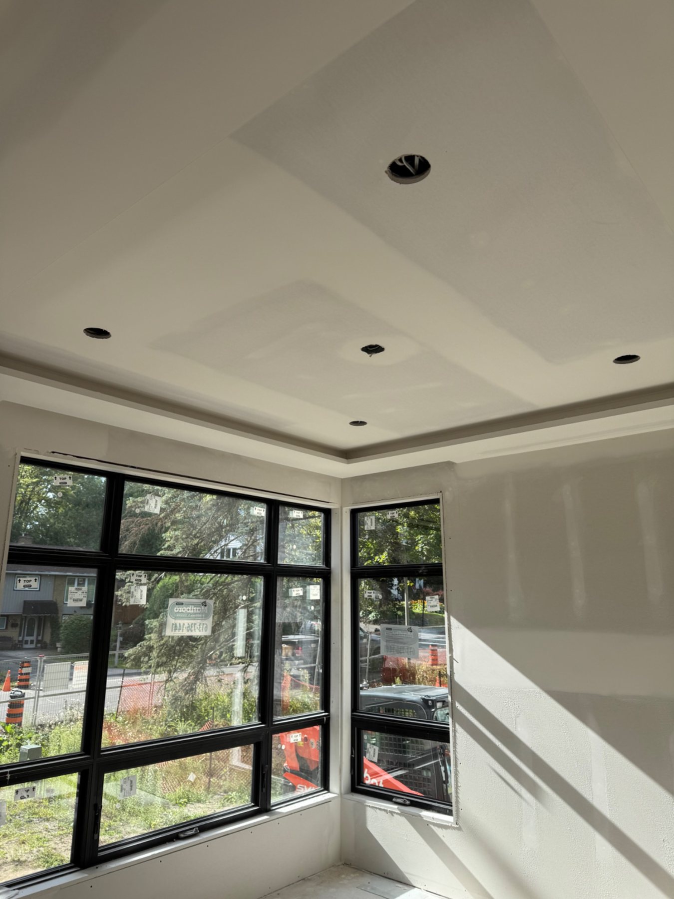 Finished drywall around modern windows and tray ceiling
